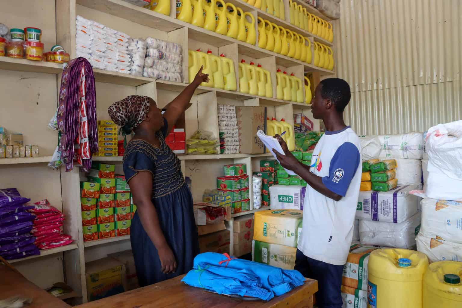 Shopkeeper stocking shelves in a local duka